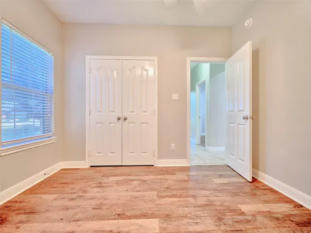 an empty room with window and wooden floor