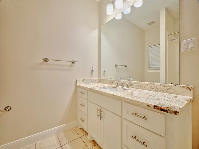 a bathroom with a granite countertop sink and a mirror