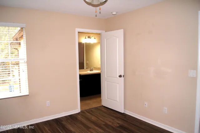 an empty room with wooden floor and cabinet