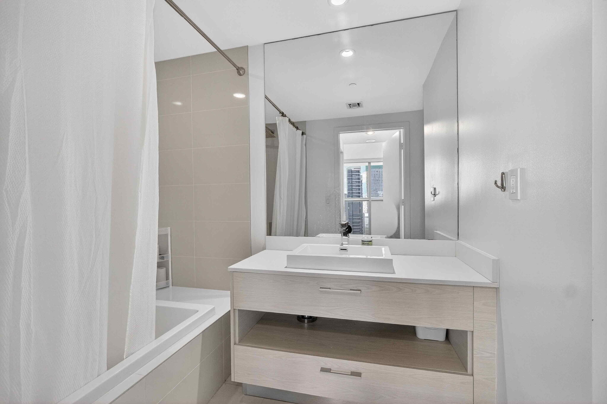 55 Southwest 9th Street, Unit 3704 Miami, FL 33130 - Photo 14 of 53 a bathroom with a sink and a mirror