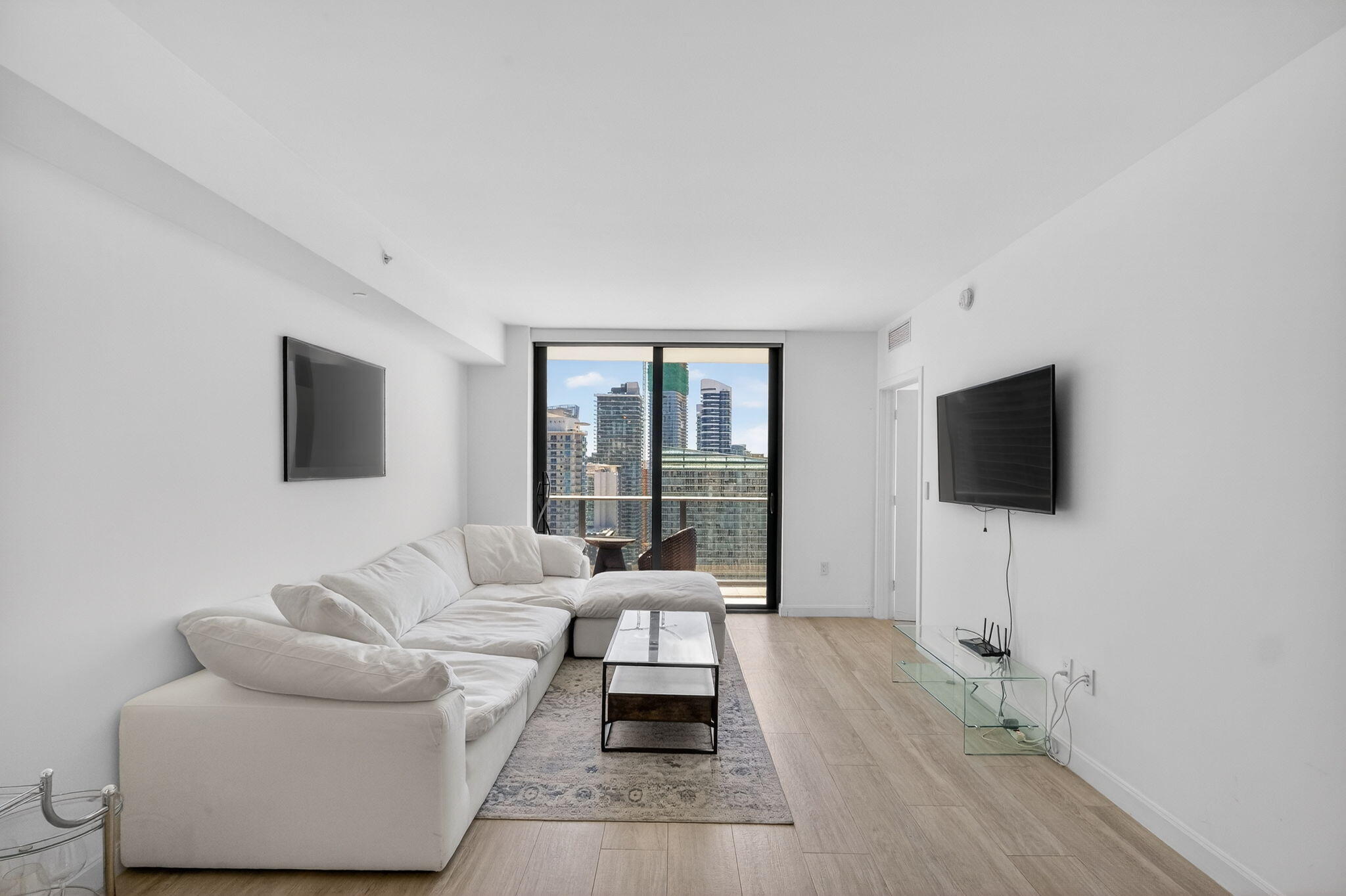 55 Southwest 9th Street, Unit 3704 Miami, FL 33130 - Photo 2 of 53 a living room with furniture and a flat screen tv