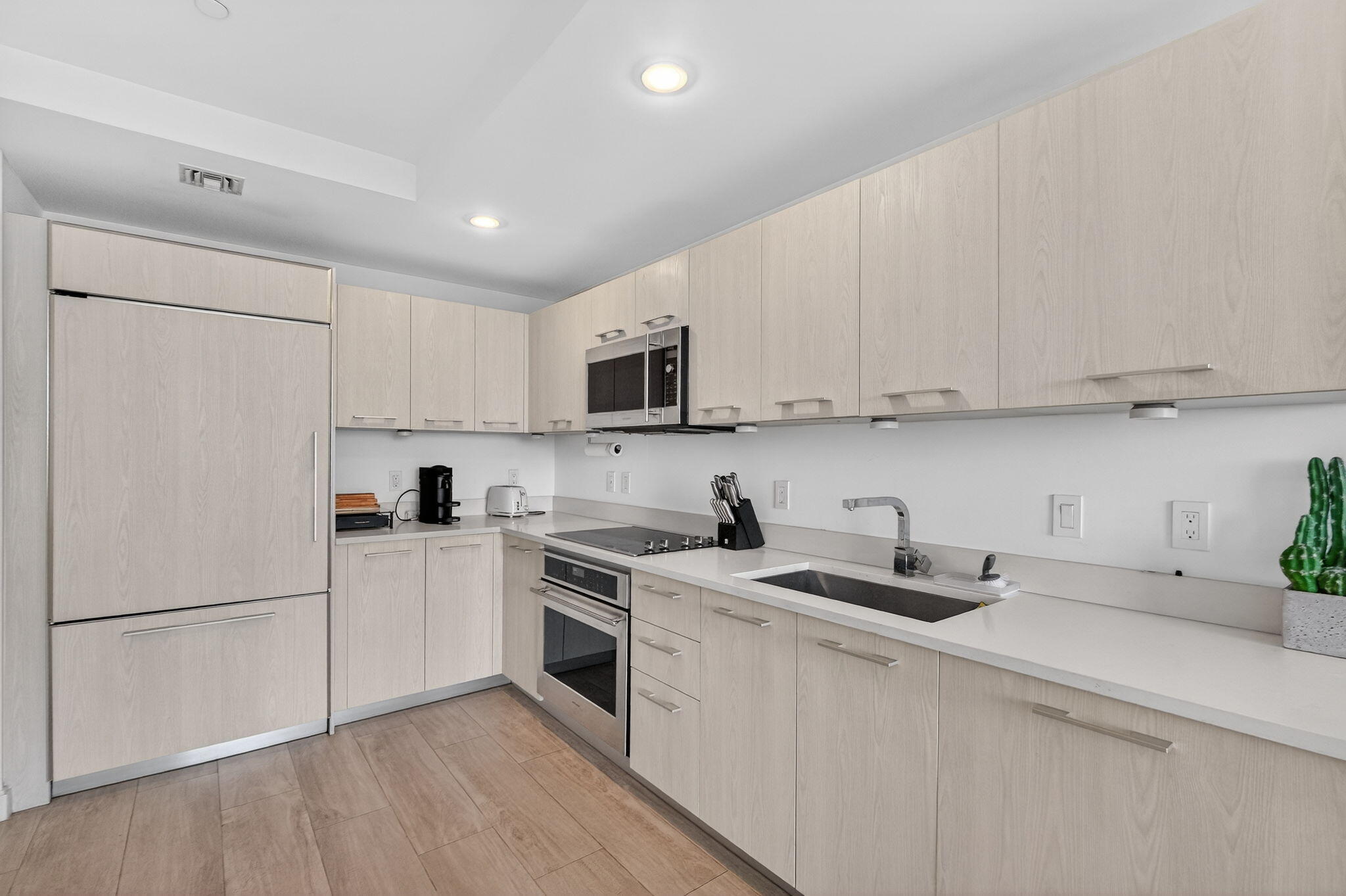 55 Southwest 9th Street, Unit 3704 Miami, FL 33130 - Photo 5 of 53 a kitchen with cabinets a sink and white appliances