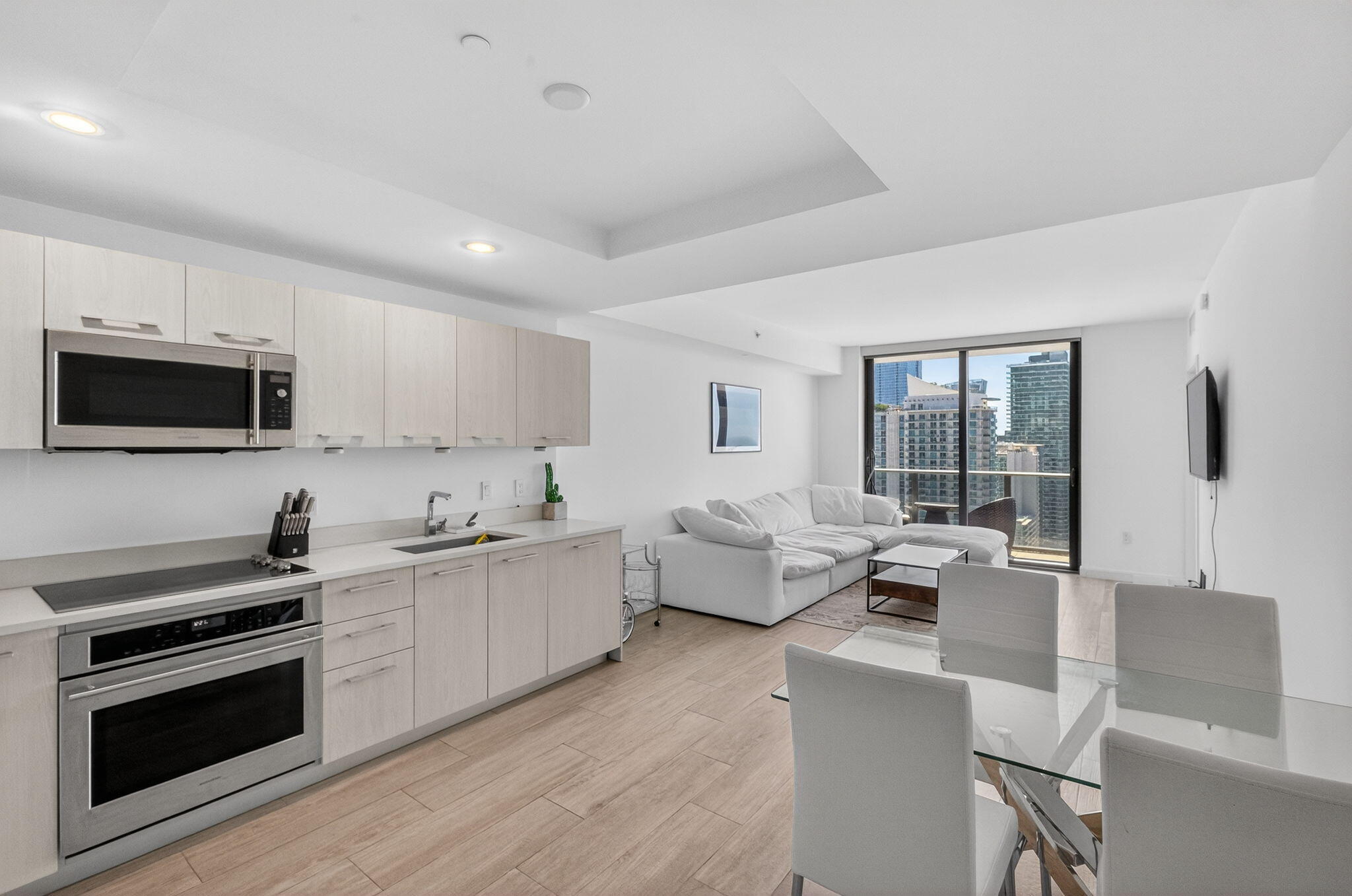 55 Southwest 9th Street, Unit 3704 Miami, FL 33130 - Photo 6 of 53 a large white kitchen with stainless steel appliances granite countertop a stove and a sink with granite countertops
