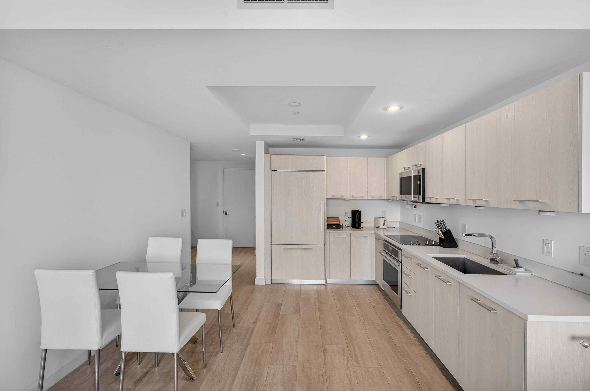 55 Southwest 9th Street, Unit 3704 Miami, FL 33130 - Photo 9 of 53 a kitchen with white cabinets and stainless steel appliances