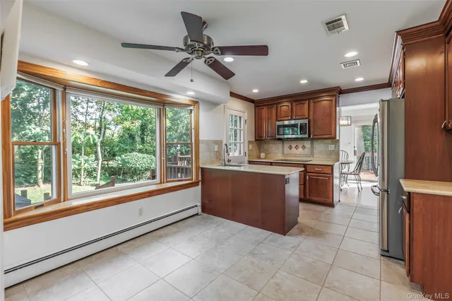 a large kitchen with a large window and stainless steel appliances