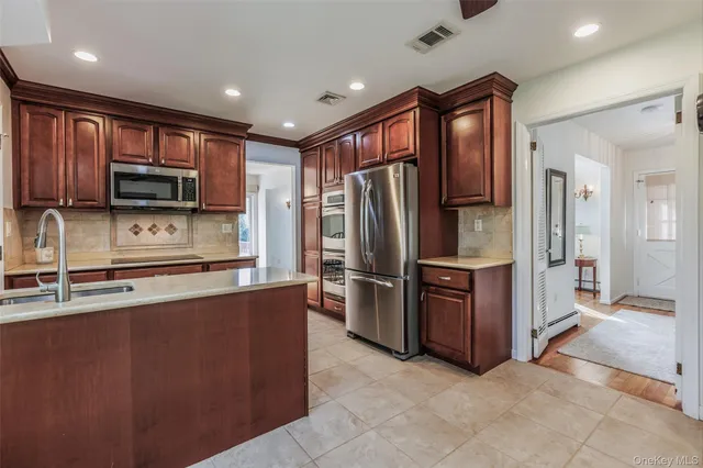a kitchen with stainless steel appliances granite countertop a refrigerator and a stove top oven