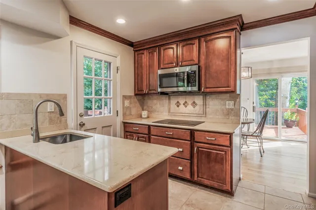 a kitchen with kitchen island granite countertop a stove top oven microwave and a sink