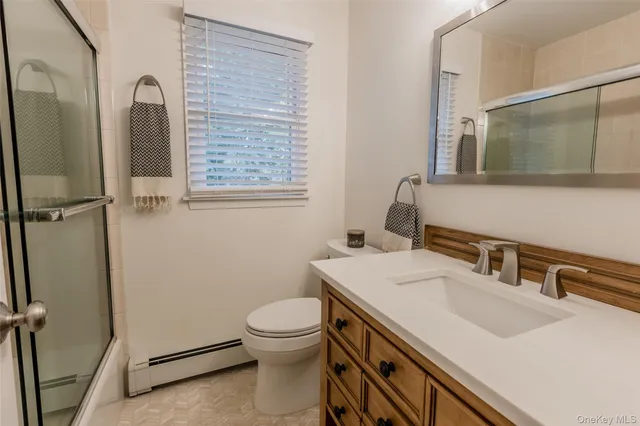 a bathroom with a sink a toilet and mirror
