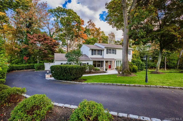 a front view of a house with a yard and trees
