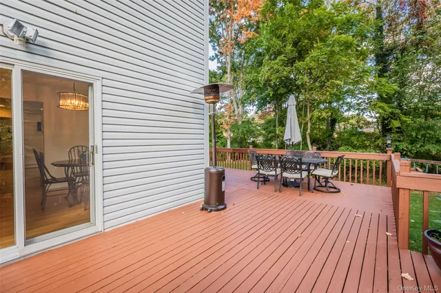a view of a patio with dining table and chairs with wooden floor and fence