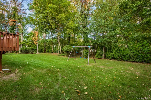 a view of a backyard with a slide trees and wooden fence