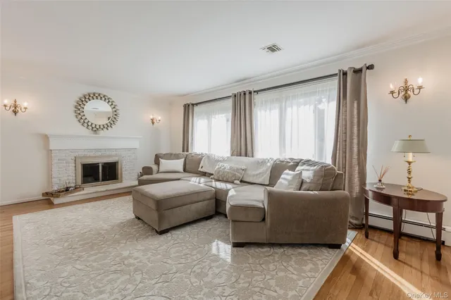 a living room with furniture a large window and a fireplace