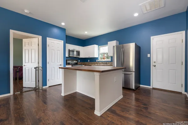 a kitchen with stainless steel appliances granite countertop a refrigerator a sink and a stove