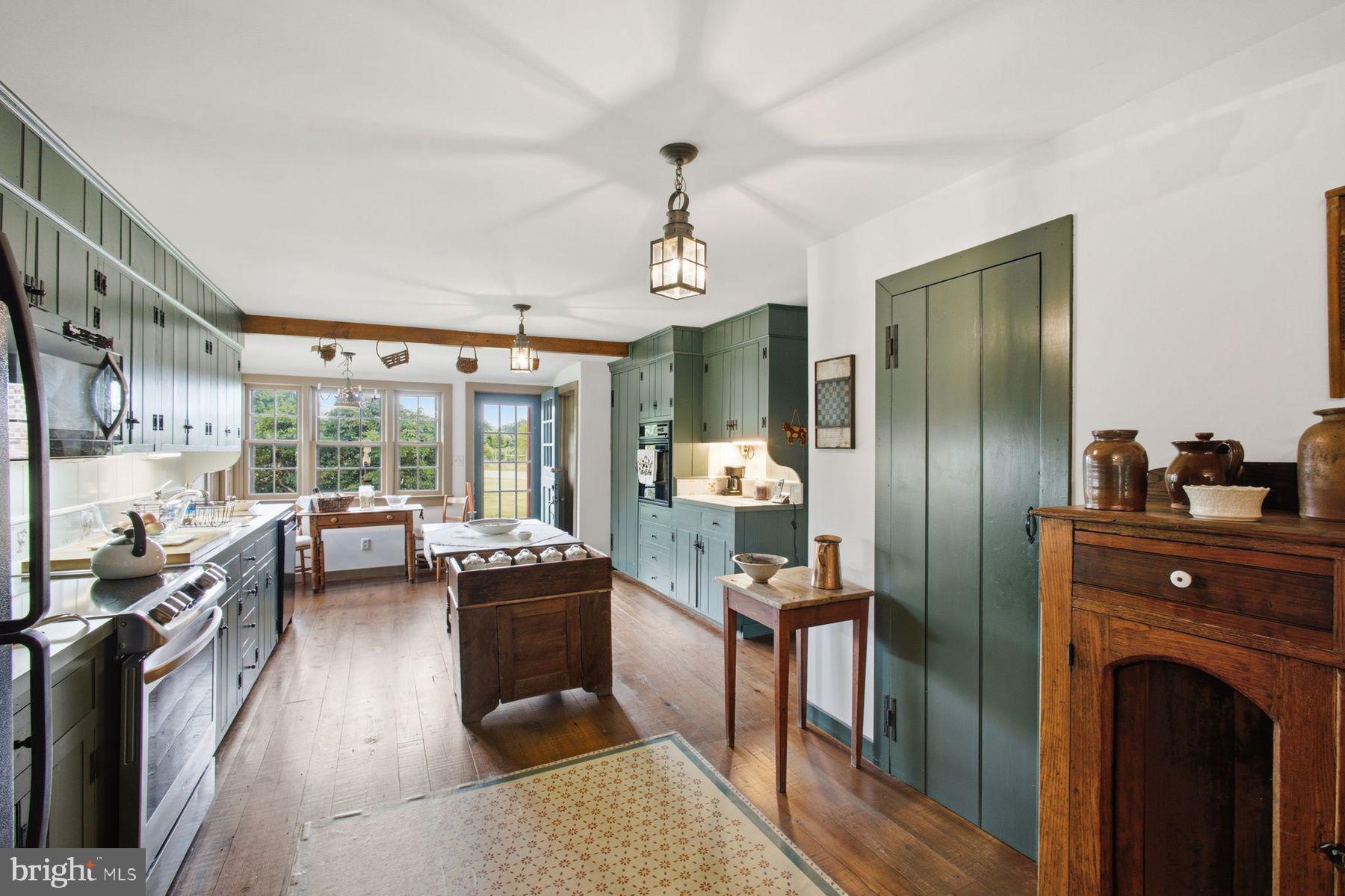 255 Old Mill Road Greenwich, NJ 08323 - Photo 11 of 35 a kitchen with stainless steel appliances granite countertop a refrigerator a sink dishwasher a stove and a dining table with wooden floor