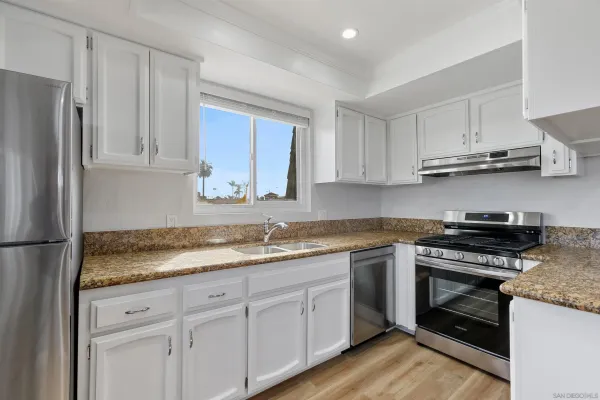 a kitchen with stainless steel appliances granite countertop a stove a refrigerator and a sink