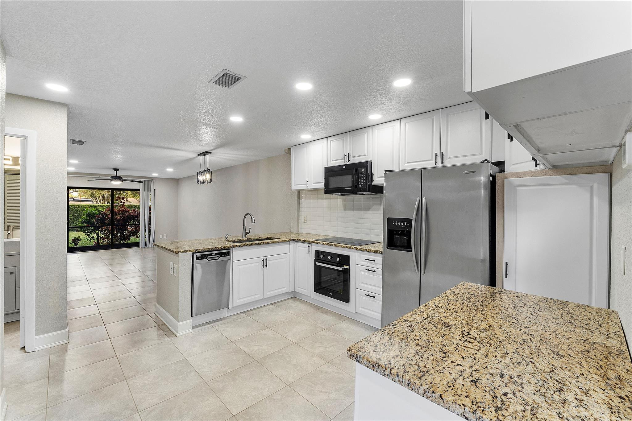 a kitchen with stainless steel appliances granite countertop a refrigerator and a stove top oven