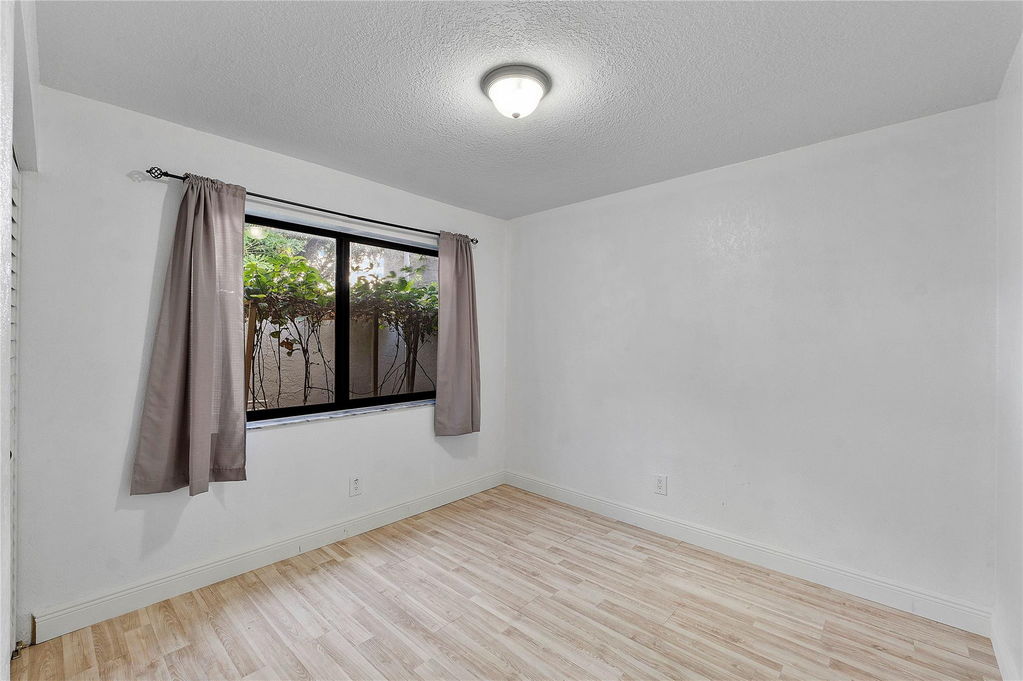 5290 Gate Lake Road, Unit 5290 Tamarac, FL 33319 - Photo 12 of 18 an empty room with wooden floor and windows