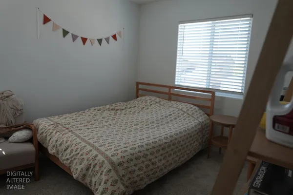a bed sitting in a bedroom next to a window