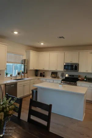 a kitchen with a sink a microwave and cabinets