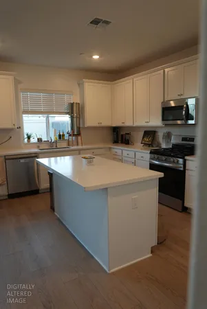 a kitchen with stainless steel appliances a sink a stove top oven a counter space and cabinets