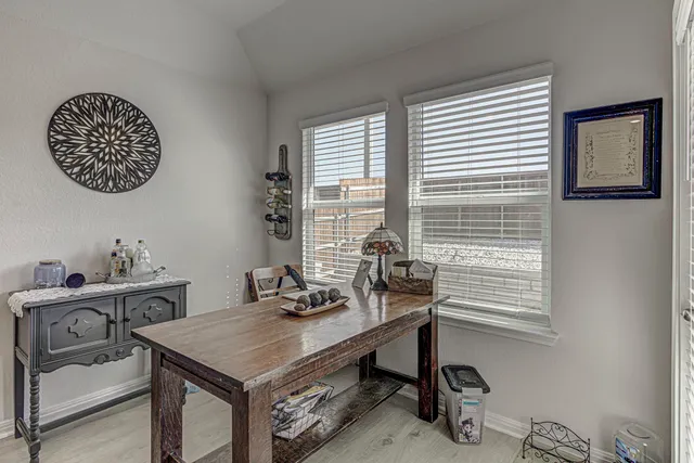 a room with a table chairs and a window