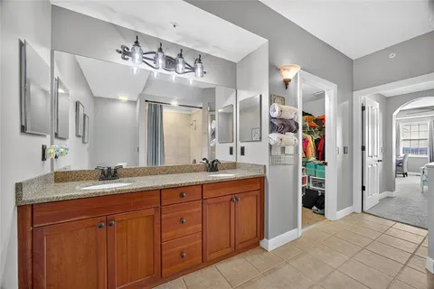 a spacious bathroom with a granite countertop sink and mirror