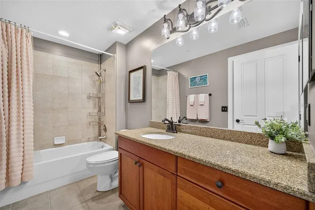 a bathroom with a granite countertop sink a toilet and bathtub