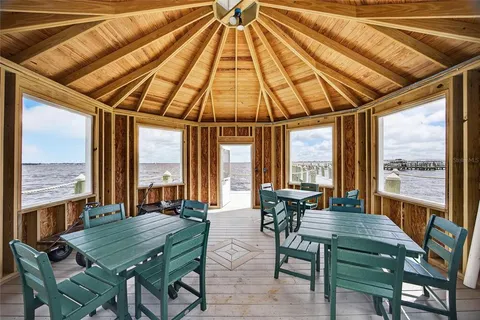 a dining room with furniture and large windows