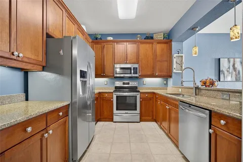 a kitchen with stainless steel appliances granite countertop a refrigerator and a sink