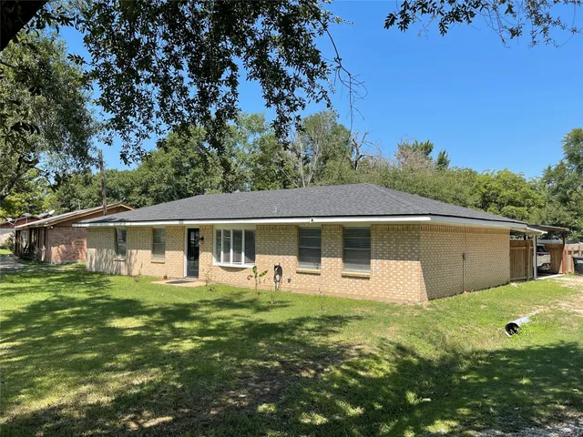 a front view of house with yard and trees in the background