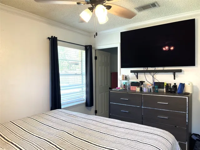 a bedroom with a bed and a flat screen tv