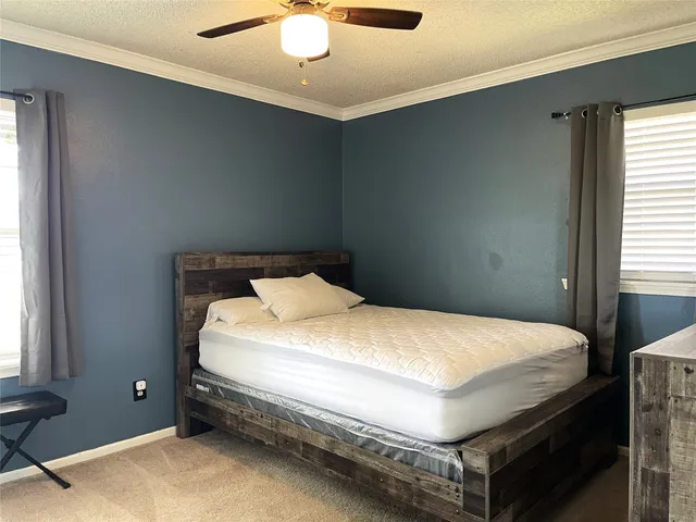 a bed sitting in a bedroom next to a window