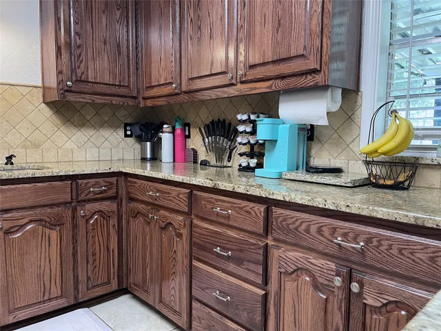 a kitchen with granite countertop wooden cabinets stainless steel appliances and a sink