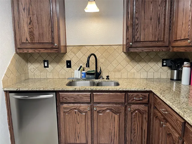 a kitchen with granite countertop a sink and cabinets