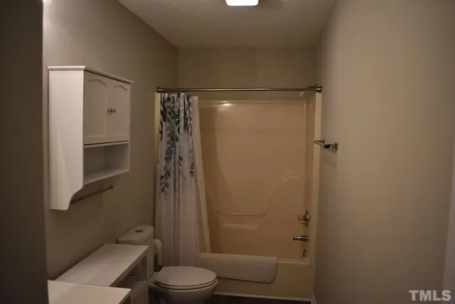 a bathroom with a shower a toilet and a shower