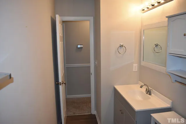a bathroom with a sink and mirror with shower