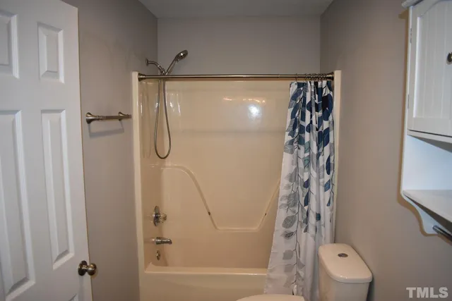 a bathroom with a shower curtain and a window