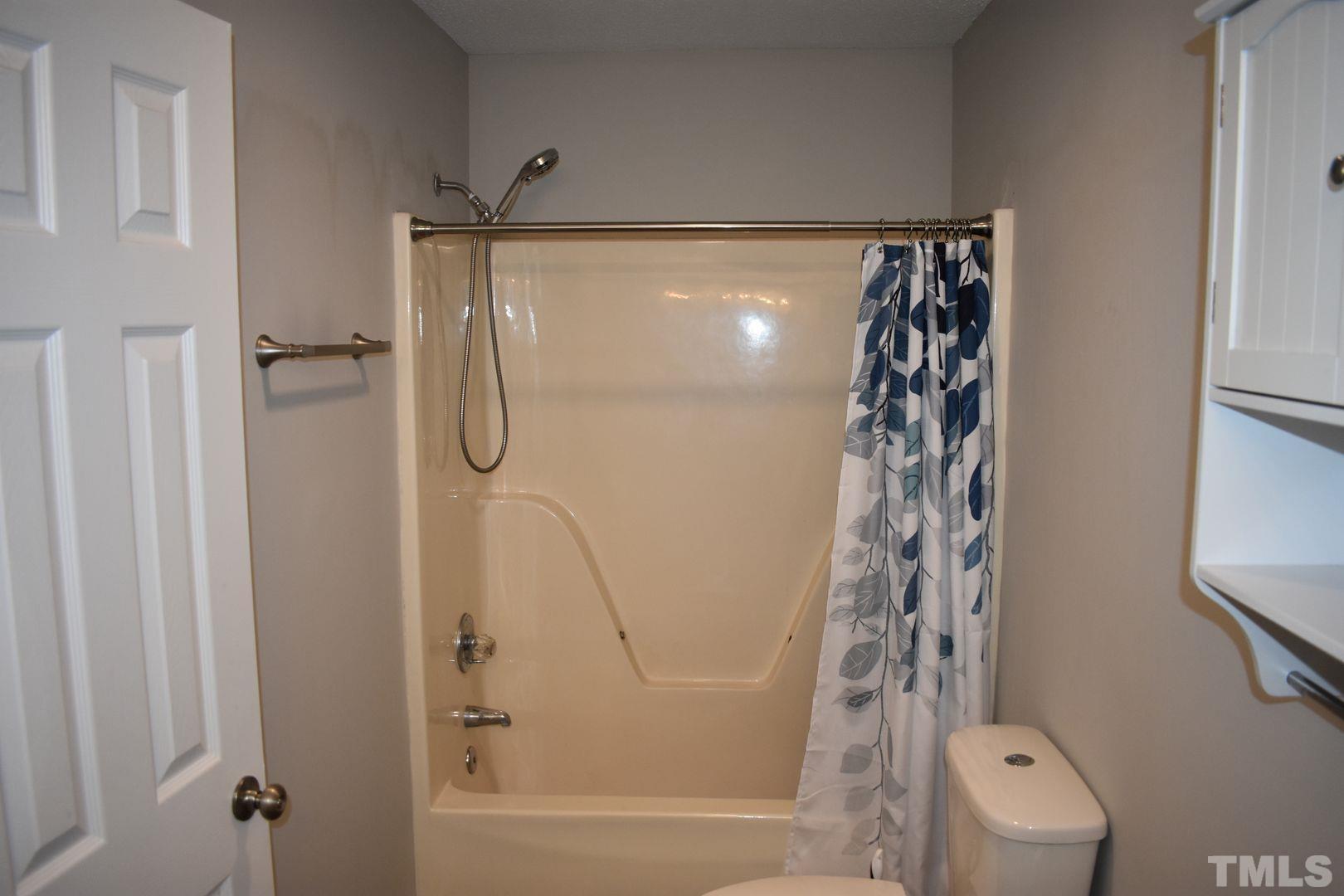 614 Mc Kay Street Erwin, NC 28339 - Photo 17 of 24 a bathroom with a shower curtain and a window