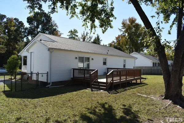 a view of a house with backyard and a tree
