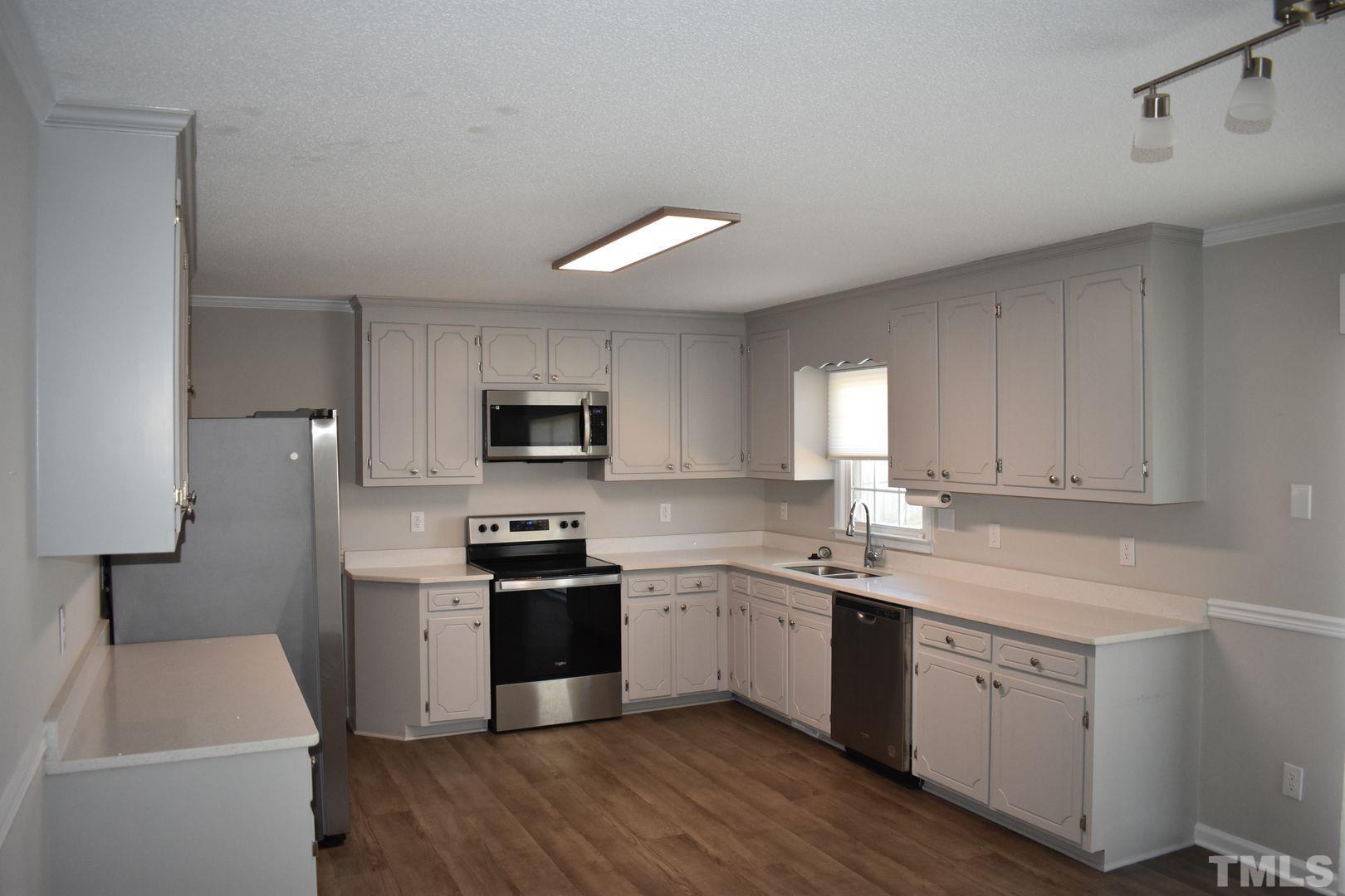 614 Mc Kay Street Erwin, NC 28339 - Photo 6 of 24 a kitchen with a sink white cabinets and stainless steel appliances