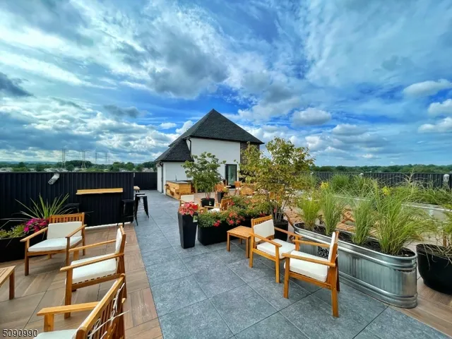a view of a terrace with couches and lounge chairs