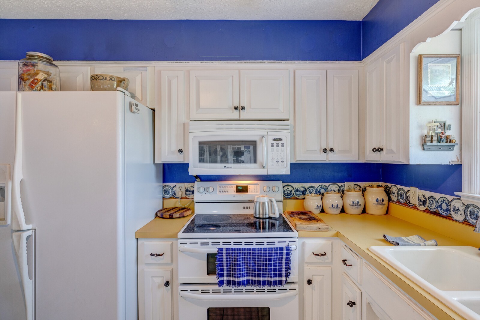 7486 Deer Ridge Road Primm Springs, TN 38476 - Photo 24 of 69 a kitchen with stainless steel appliances granite countertop a refrigerator a stove and white cabinets with wooden floor