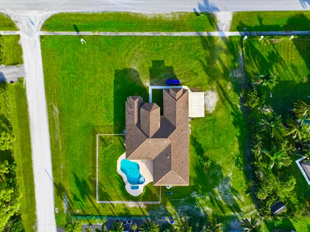 a hallway with a view of living room with furniture and wooden floor