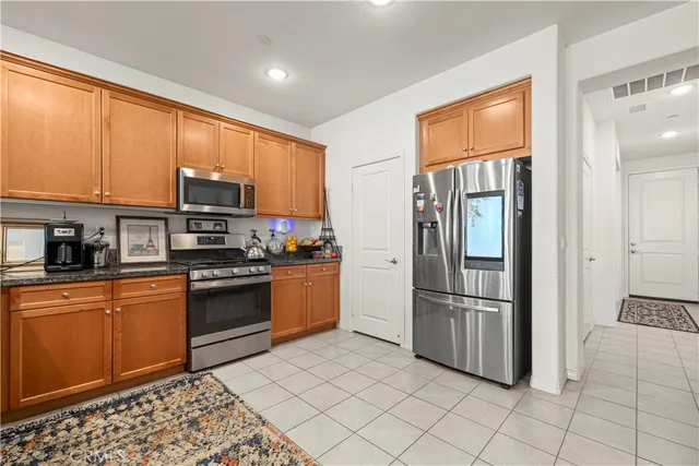 a kitchen with stainless steel appliances granite countertop a refrigerator a sink a stove a microwave and dining table