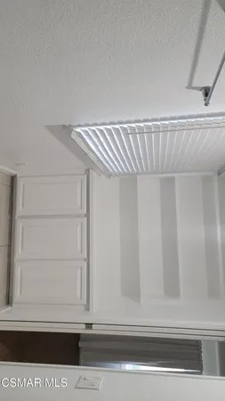 a view of walk in closet with empty racks