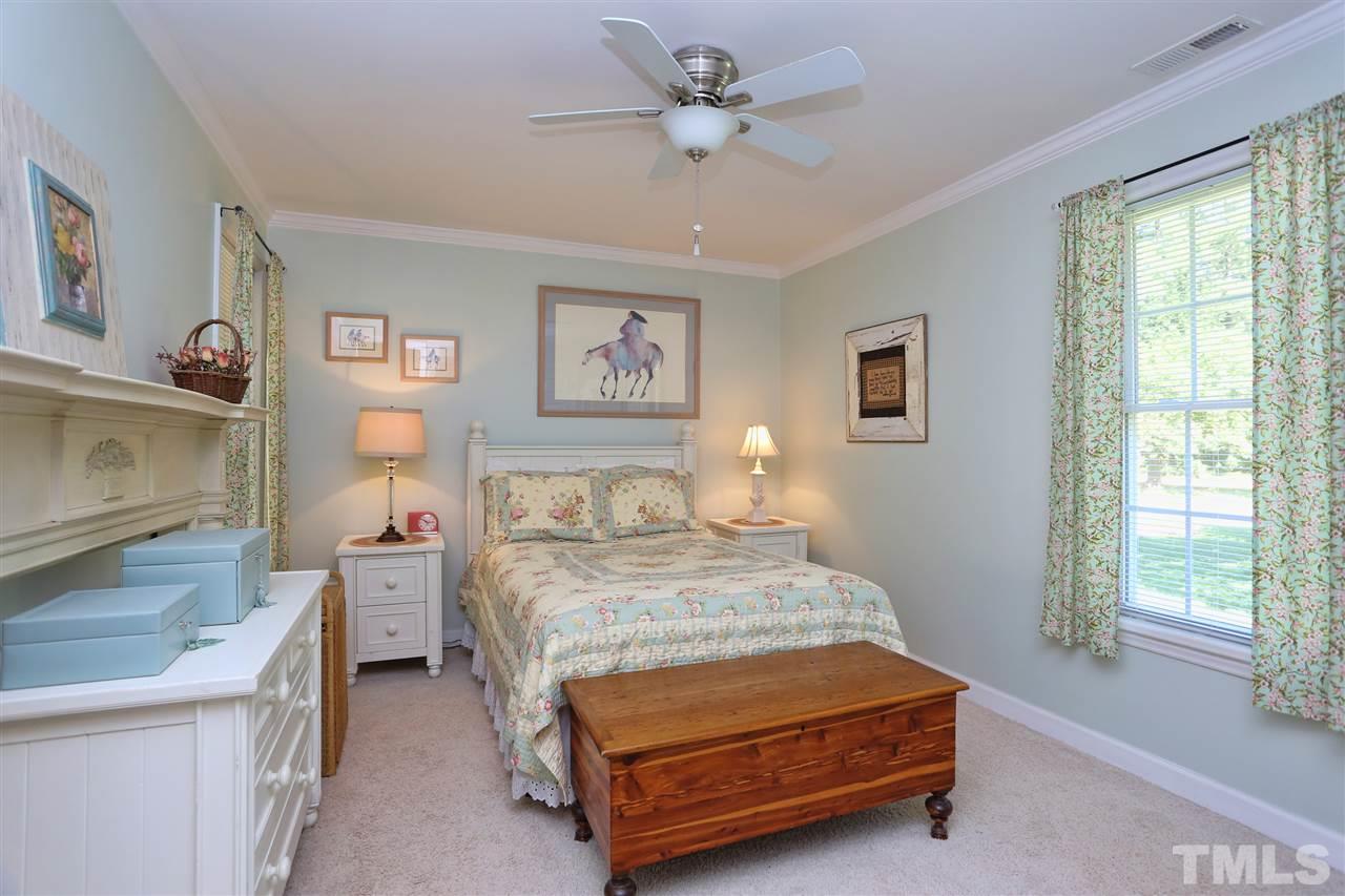 1809 Albacore Lane Raleigh, NC 27612 - Photo 14 of 25 a bedroom with a bed and a chandelier