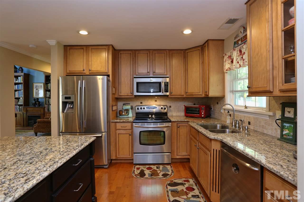 1809 Albacore Lane Raleigh, NC 27612 - Photo 3 of 25 a kitchen with granite countertop stainless steel appliances a sink stove refrigerator and cabinets