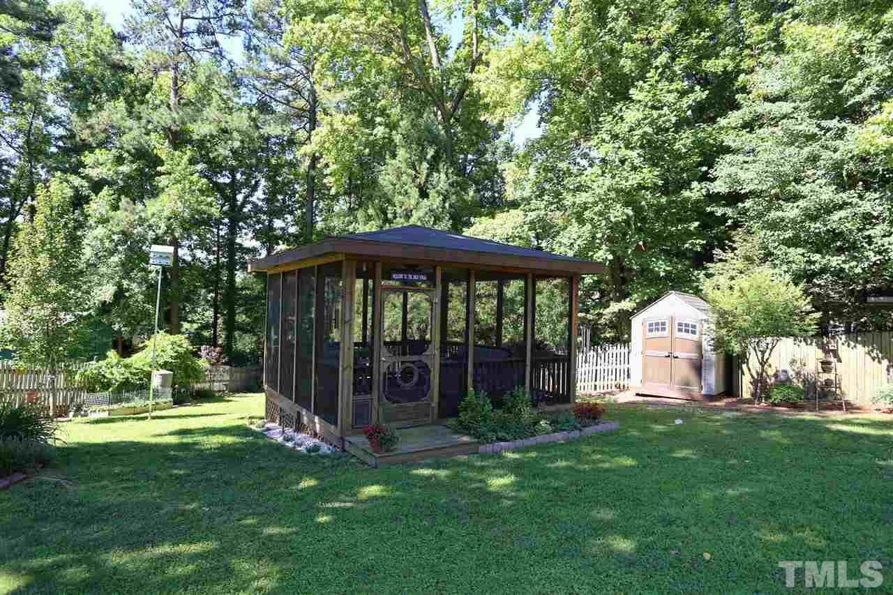 1809 Albacore Lane Raleigh, NC 27612 - Photo 22 of 25 a front view of a house with a yard table and garden