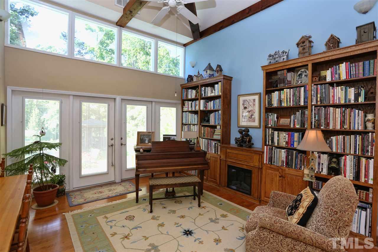 1809 Albacore Lane Raleigh, NC 27612 - Photo 10 of 25 a living room with a couch bookshelf and a fireplace