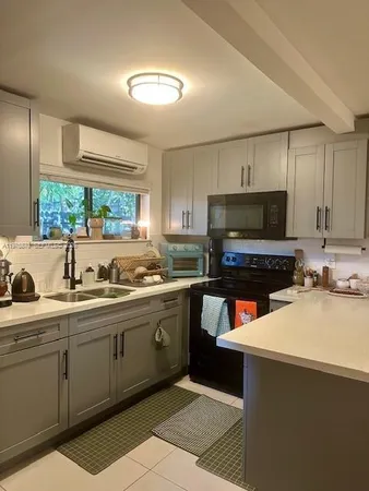 a kitchen with a sink a counter top space appliances and cabinets